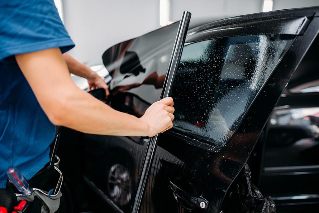 specialist applying car tinting film