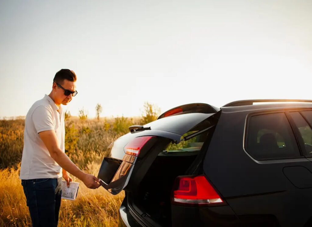 Young man opening car trunk protected by high-quality paint protection film